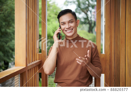 Confident Young Man Calling Friend Confident Young Man Calling Friend 88820377