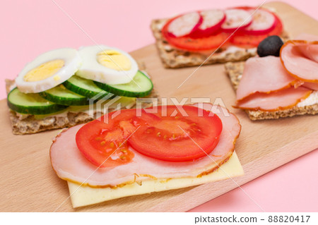 Whole Grain Crispbread with Ham, Tomato, Radish, Cucumber and Cheese Whole Grain Crispbread with Ham, Tomato, Radish, Cucumber and Cheese 88820417