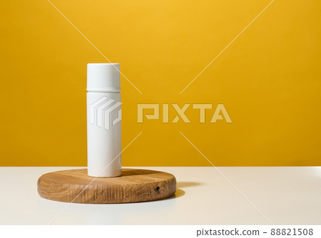 white plastic round tube for cosmetics, creams and liquid gels on a wooden podium, yellow background white plastic round tube for cosmetics, creams and liquid gels on a wooden podium, yellow background 88821508