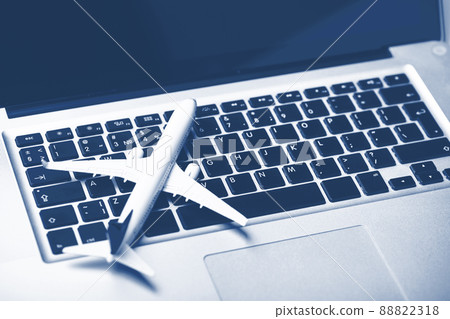 Plane on laptop keyboard. Booking tickets online Blue tone 88822318