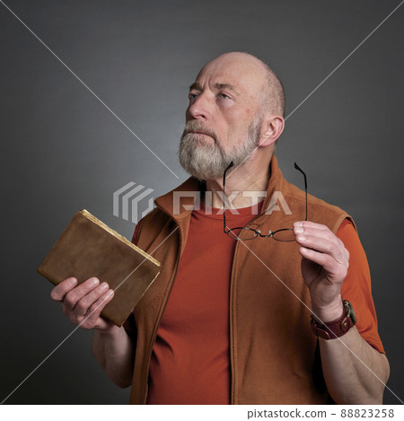 bearded senior man with book and glasses bearded senior man with book and glasses 88823258