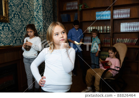 Thoughtful preteen girl solving puzzle in escape room 88826464