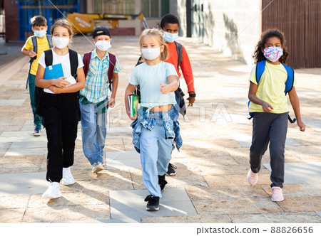 Preteen schoolchildren in face masks going to college in autumn day Preteen schoolchildren in face masks going to college in autumn day 88826656