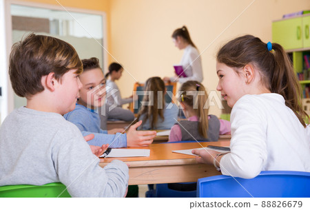 Schoolchildren chatting during lesson 88826679