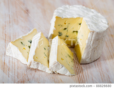 Slices of tasty soft blue cheese with blue mold at wooden board 88826680