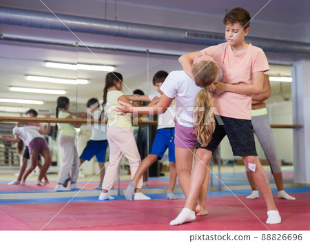 Boys and girls learn together in self-defense lesson to do painful head grab 88826696