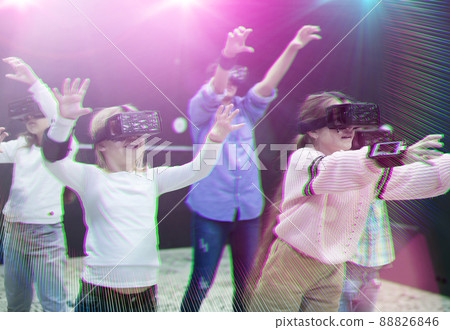 Happy tweens in VR glasses playing virtual reality games, toned image 88826846