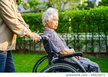 Asian elderly woman disability patient sitting on wheelchair in park, medical concept. Asian elderly woman disability patient sitting on wheelchair in park, medical concept. 88828872