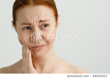 A Woman Suffering From Strong Teeth Pain, Touching Cheek With Hand. Dentistry Concept. A Woman Suffering From Strong Teeth Pain, Touching Cheek With Hand. Dentistry Concept. 88828915