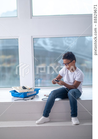 A dark-skinned boy constructing a transformer and looking busy A dark-skinned boy constructing a transformer and looking busy 88829671