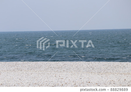 海岸景觀,深藍綠色的海面,藍天、地平線、白浪和白色鵝卵石海灘 海岸景觀,深藍綠色的海面,藍天、地平線、白浪和白色鵝卵石海灘 88829889