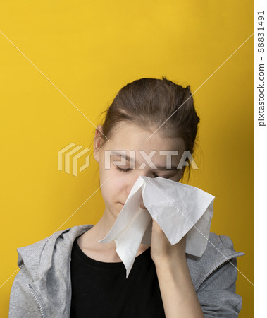 Young girl crying wiping away tears with tissue on yellow 88831491