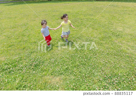 Sister and brother walking hand in hand in the park 88835117
