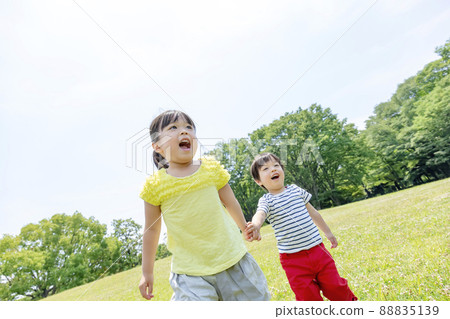 Sister and brother walking hand in hand in the park 88835139
