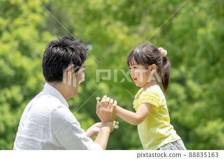 Father and daughter playing with flowers in the park Father and daughter playing with flowers in the park 88835163