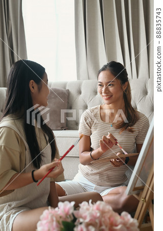 Happy mother and adorable little daughter enjoy painting picture together at home. 88835743