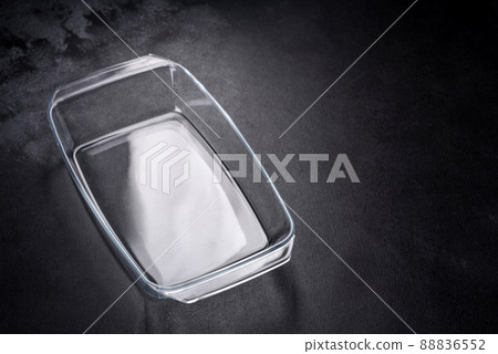 A rectangular glass empty dish for baking on a dark concrete background A rectangular glass empty dish for baking on a dark concrete background 88836552