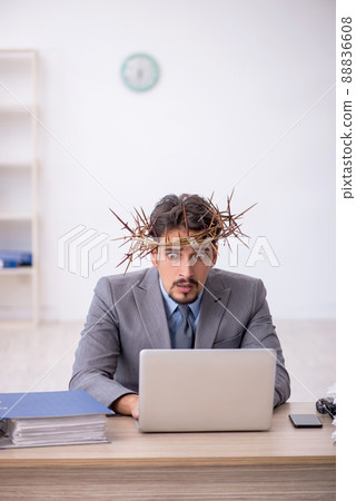 Young male employee wearing prickly wreath on head 88836608
