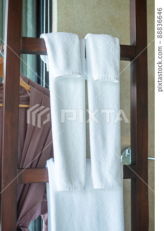 Closeup clean bathrobe and towel hanging in wooden wardrobe at luxury hotel. Relax and travel concept Closeup clean bathrobe and towel hanging in wooden wardrobe at luxury hotel. Relax and travel concept 88836646
