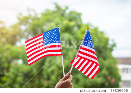 hand holding United States of America flag on green background. USA holiday of Veterans, Memorial, Independence ( Fourth of July) and Labor Day concept hand holding United States of America flag on green background. USA holiday of Veterans, Memorial, Independence ( Fourth of July) and Labor Day concept 88836666
