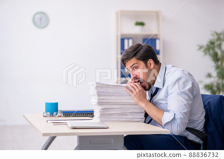 Young male employee and too much work in the office 88836732