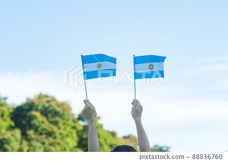 hand holding Argentina flag on nature background. 9th July of Independence day, 25th May of Revolution day and happy celebration concepts hand holding Argentina flag on nature background. 9th July of Independence day, 25th May of Revolution day and happy celebration concepts 88836760