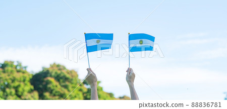 hand holding Argentina flag on nature background. 9th July of Independence day, 25th May of Revolution day and happy celebration concepts hand holding Argentina flag on nature background. 9th July of Independence day, 25th May of Revolution day and happy celebration concepts 88836781
