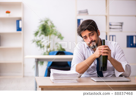 Young alcohol addicted employee sitting in the office 88837468