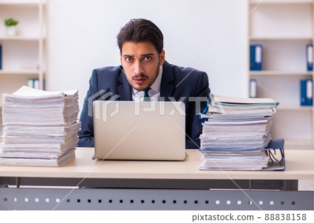 Young businessman employee and too much work in the office Young businessman employee and too much work in the office 88838158