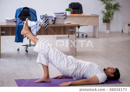 Young male employee doing sport exercises in the office 88838173