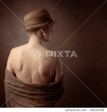 Attractive and slim woman in hat on a brown background. 88838396