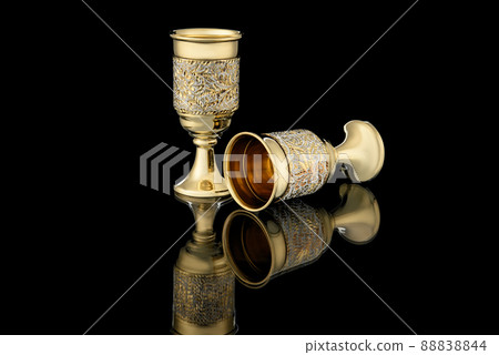 Antique Vintage Brass Shot Glass Gilded on Black background Antique Vintage Brass Shot Glass Gilded on Black background 88838844