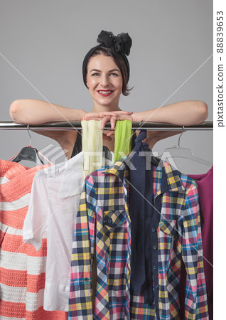 Attractive woman standing near the racks of clothes . Attractive woman standing near the racks of clothes . 88839653
