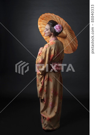 Young beautiful woman in traditional Japanese kimono with umbrella. 88840333