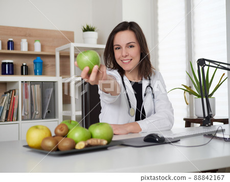 Young Female nutritionist holding a green apple 88842167