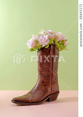 Cowboy boots shoes and bouquet of rose flowers on green background Cowboy boots shoes and bouquet of rose flowers on green background 88843172