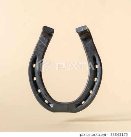 Horseshoe iron on beige background concept of american wild west. Horseshoe iron on beige background concept of american wild west. 88843175