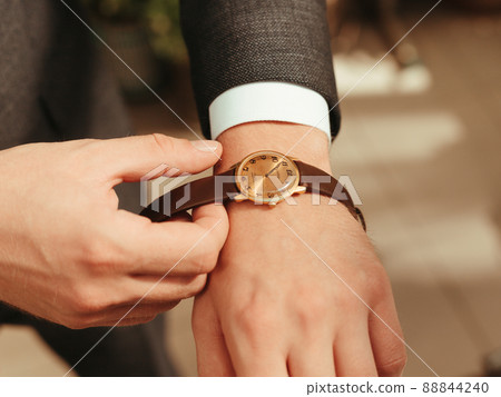 Businessman wearing the wristwatch. Grain effect Businessman wearing the wristwatch. Grain effect 88844240