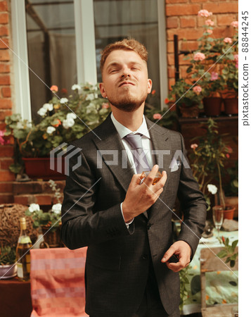 fashion young man wearing black tuxedo, grain effect studio blond 88844245