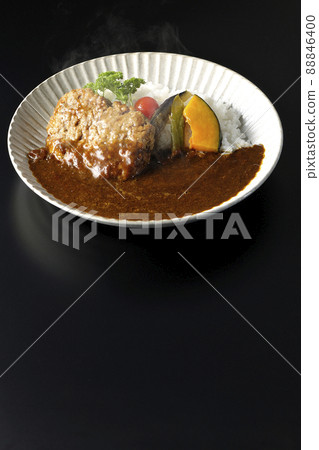 Photographed a hot hamburger curry with stewed vegetables and parsley on a black background 88846400