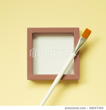 Pink picture frame with paint brush on yellow background. top view, copy space Pink picture frame with paint brush on yellow background. top view, copy space 88847360
