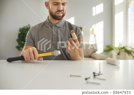 Man hits his finger with hammer and has to wear support brace on his injured finger Man hits his finger with hammer and has to wear support brace on his injured finger 88847933