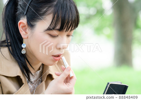 在公園裡塗口紅的女人 88848409