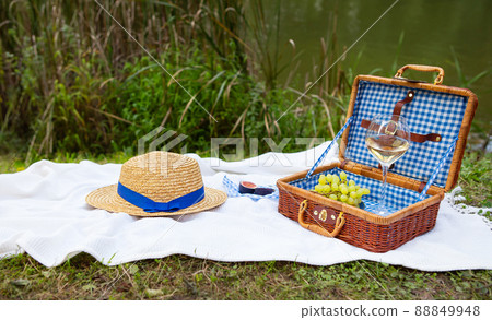 Romantic picnic in the park on the grass against the backdrop of a beautiful lake, delicious food Romantic picnic in the park on the grass against the backdrop of a beautiful lake, delicious food 88849948