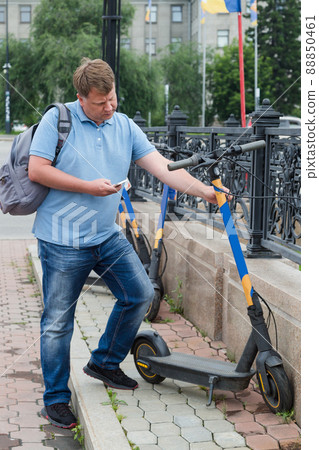 A man aged 40-44 rents an electric scooter to work as a courier 88850461