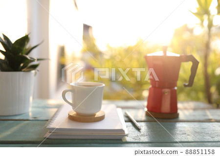 Coffee and moka pot and notebook on blue wooden table outdoor 88851158