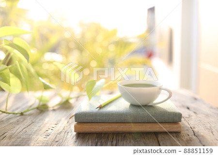 Coffee cup and notebooks and pencil on old brown wooden table Coffee cup and notebooks and pencil on old brown wooden table 88851159