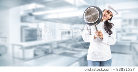 Cook brunette girl smiles lovely with a pan behind in a kitchen kitchen 88851557