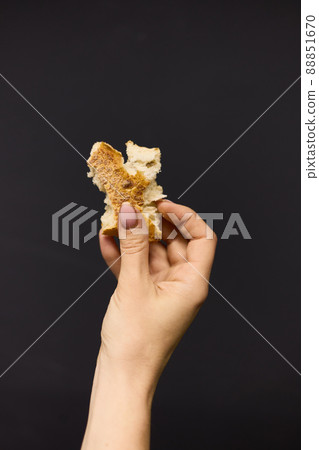 Women's hands break off a piece of fresh bread, close up 88851670