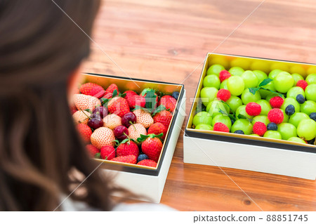 Woman looking at boxed fruit 88851745